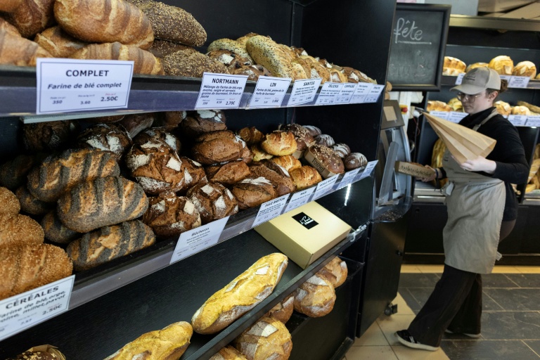 Une employée sert du pain à des clients dans une boulangerie à Quimper, le 1er mai 2026 dans le Finistère