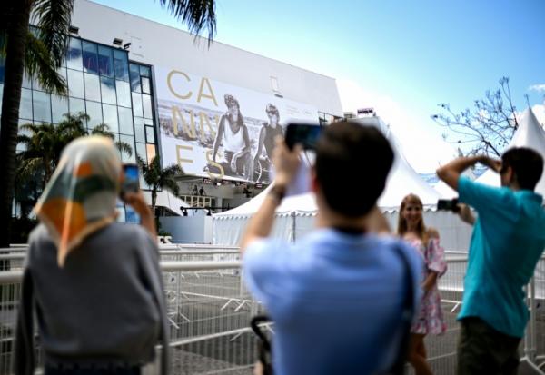 Des passants photographient la façade du Palais du festival à Cannes le 11 mai 2026
