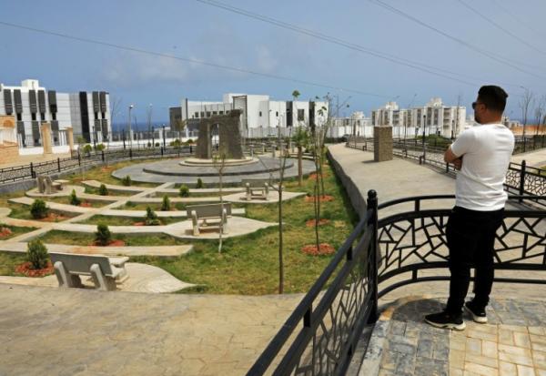 Un homme observe le nouveau projet de logements en construction dans le quartier d'Al-Salam à Derna, le 17 mai 2026, dans le cadre du plan de reconstruction de la ville, près de trois ans après le passage dévastateur d'une tempête qui a fait près de 4 000 victimes