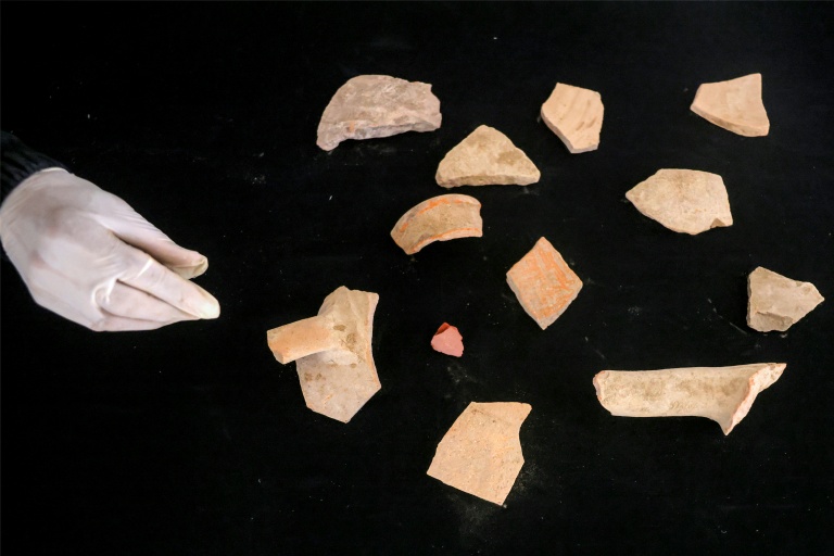 Une membre de l'association Mayasem pour la culture et les arts examine des tessons de poterie, dans le dépôt de patrimoine culturel à Khan Younès, dans le sud de la bande de Gaza, le 11 juillet 2026