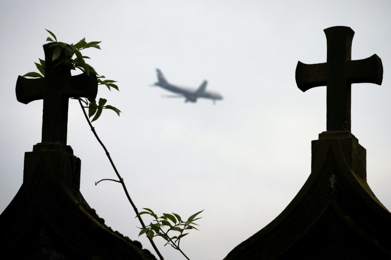 Un avion passe au-desusus du cimetière dans le village abandonné de Goussainville, le 26 novembre 2013, dans le Val-d'Oise