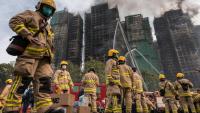 Des pompiers se préparent après qu'un important incendie a ravagé plusieurs immeubles d'appartements du complexe résidentiel Wang Fuk Court à Hong Kong, le 27 novembre 2025