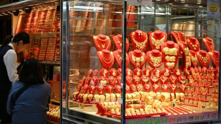 Des passants devant la vitrine d'une boutique d'or, à Hong Kong, le 26 janvier 2026