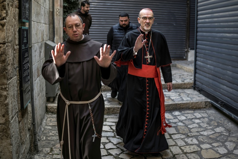 Le cardinal Pierbattista Pizzaballa (D), patriarche latin de Jérusalem, arrive accompagné de frères franciscains à l’église du Saint-Sépulcre pour célébrer la messe de Pâques, à huis clos en raison de la guerre, dans la vieille ville de Jérusalem, le 5 avril 2026