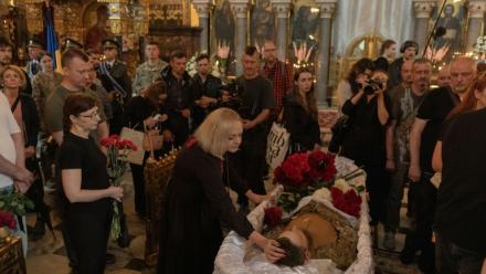 Des proches et des amis pleurent près du cercueil d’Oleksiï Ioukov, chef de l'unité de recherche ukrainienne Platsdarm, lors de ses funérailles à Kiev, le 8 août 2026