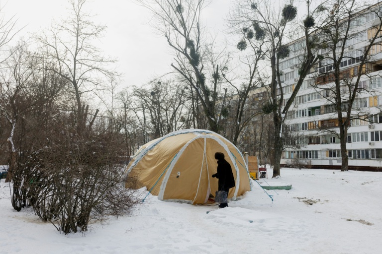 Une femme entre dans une tente proposant des services d'urgence, installée pour les personnes dont les logements sont privés d'électricité ou de chauffage, à Kiev, le 18 février 2026