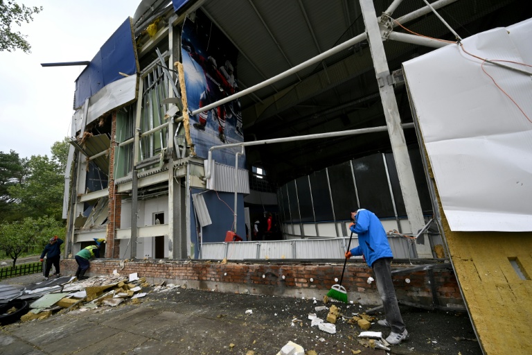 Un employé enlève des débris devant la patinoire Chalet Ice Arena de Kiev endommagée par des bombardements russes, le 19 octobre 2026 