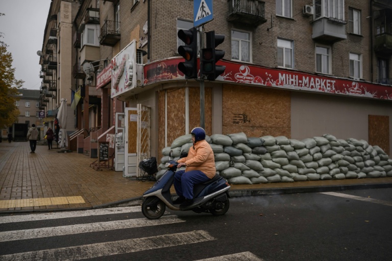Dans une rue de Droujkivka, aux façades masquées par des panneaux de bois en cas de bombardements, dans l'est de l'Ukraine, le 10 octobre 2025
 