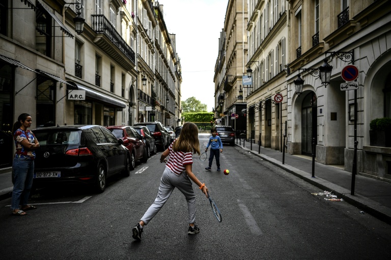 Des enfants jouent au tennis dans une rue de Paris le 21 avril 2020, en plein confinement lié au Covid-19 