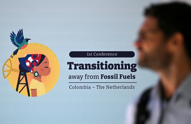 Un homme passe devant la signalétique de la conférence sur la sortie des énergies fossiles à Santa Marta, en Colombie, le 28 avril 2026