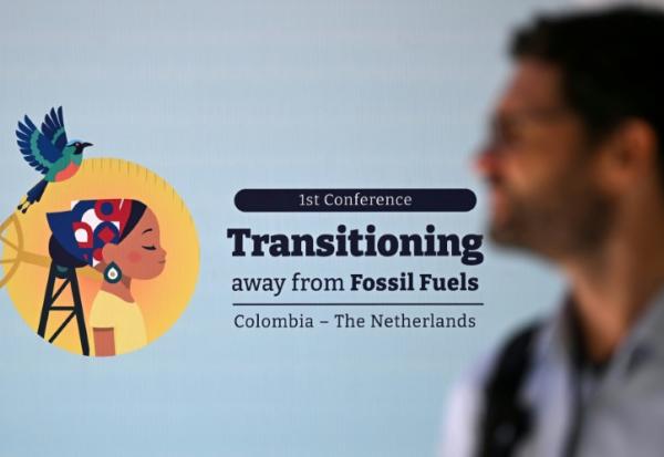 Un homme passe devant la signalétique de la conférence sur la sortie des énergies fossiles à Santa Marta, en Colombie, le 28 avril 2026