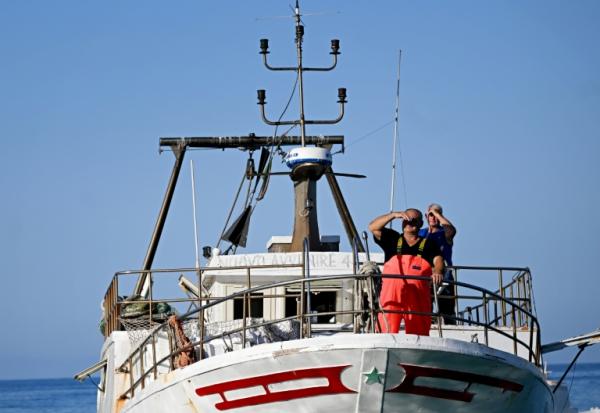 Un pêcheur sur le pont de son bateau alors qu'il arrive pour décharger sa pêche au port de Lampedusa après une journée en mer, le 8 juillet 2026 en Italie