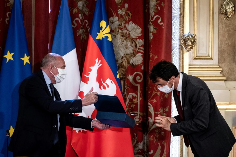 L'écologiste Grégory Doucet (d) reçoit l'écharpe de maire des mains du maire sortant et ancien ministre de l'Intérieur Gérard Collomb (g), le 4 juillet 2020