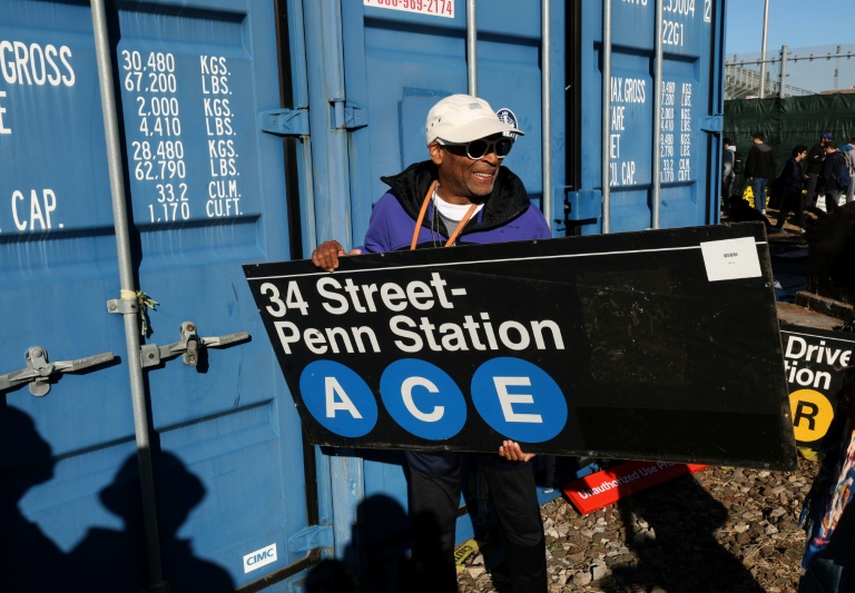 Le réalisateur Spike Lee tient une panneau d'une station de métro qu'il vient d'acheter lors de la vente annuelle organisée par la régie des transports de New York (MTA), le 9 octobre 2026