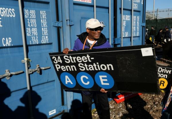 Le réalisateur Spike Lee tient une panneau d'une station de métro qu'il vient d'acheter lors de la vente annuelle organisée par la régie des transports de New York (MTA), le 9 octobre 2026
