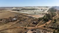 Vue aérienne de parcelles agricoles et de talus miniers en arrière-plan, dans le quartier de Snake Park, à Soweto, le 30 mai 2025 en Afrique du Sud