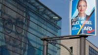 Une affiche électorale de la candidate et co-dirigeante du parti d'extrême droite Alternative pour l'Allemagne (AfD), Alice Weidel (d), devant le siège du parti chrétien-démocrate CDU avec une photo géante de son dirigeant Friedrich Merz sur sa façade, le 24 février 2025 à Berlin