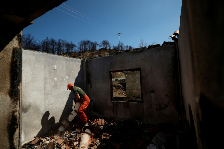 Armand Kisha déblaie les gravats dans sa maison détruite par un incendie de forêt à Skenderbegas, près de Gramsh, dans le centre de l'Albanie, le 16 septembre 2025 