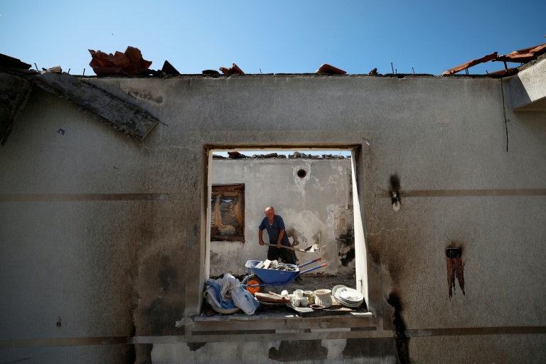 Kujtim Palloçi évacue des gravats de sa maison détruite par un incendie à Skenderbegas, près de Gramsh, dans le centre de l'Albanie, le 16 septembre 2025  