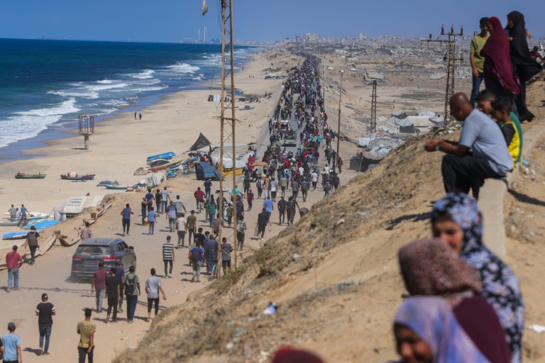 Des Palestiniens en marche sur la route al-Rachid en direction de la ville Gaza, après l'annonce du cessez-le-feu dans la bande de Gaza,  le 10 octobre 2025.

