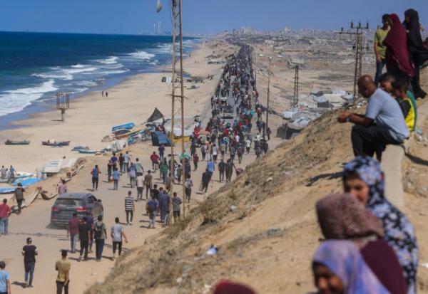Des Palestiniens en marche sur la route al-Rachid en direction de la ville Gaza, après l'annonce du cessez-le-feu dans la bande de Gaza,  le 10 octobre 2025.

