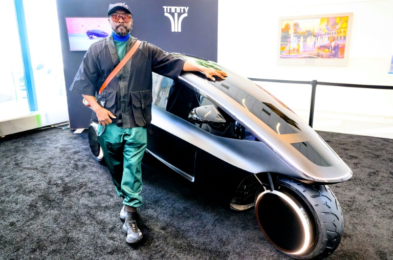 La star des Black Eyed Peas will.i.am pose devant Trinity, un tricycle électrique doté d'une IA, le 17 mars 2026 à San José aux Etats-Unis