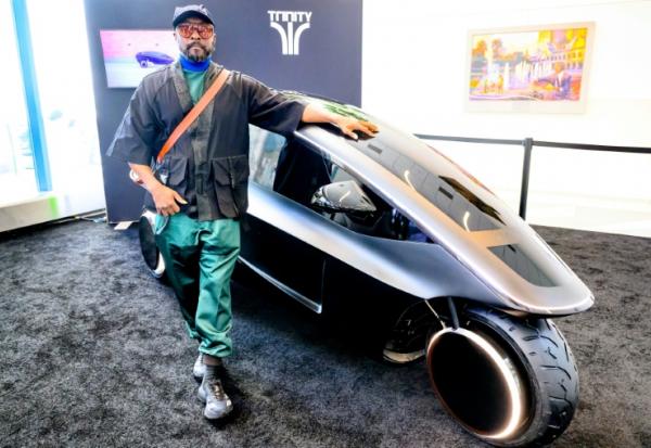 La star des Black Eyed Peas will.i.am pose devant Trinity, un tricycle électrique doté d'une IA, le 17 mars 2026 à San José aux Etats-Unis