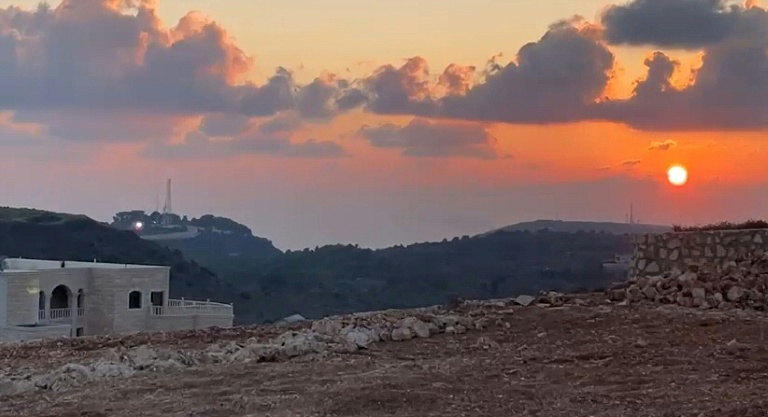 Image tirée d'une vidéo filmée par le vidéaste de l'AFP, Dylan Collins, le 13 octobre 2023 montrant un éclair (g) provenant d'une position israélienne juste avant l'impact avec des journalistes se trouvant à Alma al-Shaab, un village dans le sud du Liban, près de la frontière avec Israël