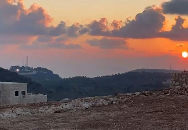 Image tirée d'une vidéo filmée par le vidéaste de l'AFP, Dylan Collins, le 13 octobre 2023 montrant un éclair (g) provenant d'une position israélienne juste avant l'impact avec des journalistes se trouvant à Alma al-Shaab, un village dans le sud du Liban, près de la frontière avec Israël
