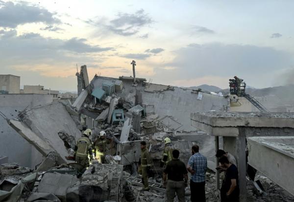 Des habitants et des secouristes se rassemblent sur un bâtiment touché par une frappe israélienne à Téhéran, le 13 juin 2025