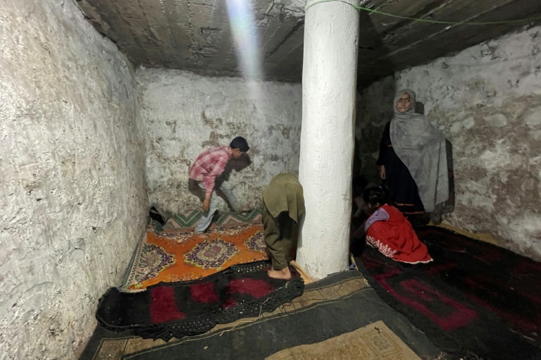 Une famille installe des tapis à l'intérieur d'un bunker souterrain dans le village de Chakothi, au Cachemire sous administration pakistanaise, près de la ligne de contrôle (LoC), le 27 avril 2025