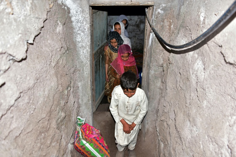 Une famille sort d'un bunker souterrain dans le village de Chakothi, au Cachemire sous administration pakistanaise, près de la ligne de contrôle (LoC), le 27 avril 2025