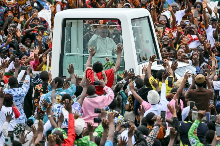 Le pape Léon XIV (C) salue la foule depuis sa papamobile à son arrivée à l'aéroport de Bamenda pour célébrer une messe, le 16 avril 2026 au Cameroun
