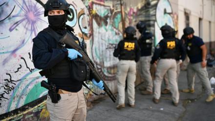 Des policiers pénètrent dans une habitation lors d'une opération antidrogue   à Santiago, le 11 décembre 2025 