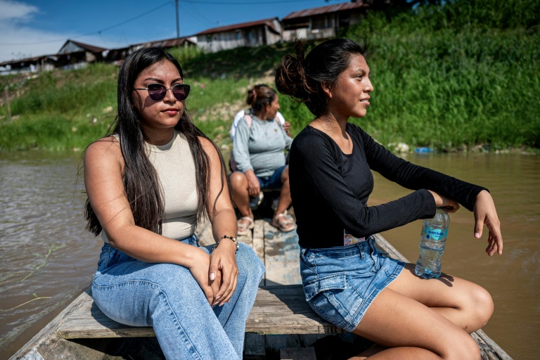 Ketsi Yahuarcani (g) et Wendy Sangama se déplacent en bateau dans le quartier de Belen, à Iquitos, dans le nord du Pérou, le 22 septembre 2026