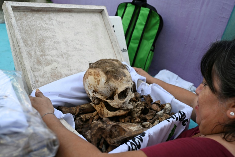 Une femme se prépare à nettoyer les restes d'un proche avant les célébrations du Jour des morts au cimetière de Pomuch, dans l'État de Campeche, au Mexique, le 18 octobre 2025