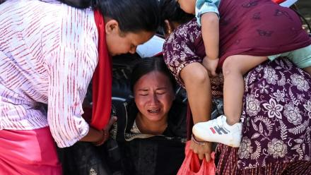 Une femme s’effondre tandis qu’elle attend l’arrivée de ses proches dans un camp militaire après avoir été secourue des zones touchées par des crues subites, dans la ville de Battar Bazar, dans le district de Nuwakot au Népal, le 27 août 2026