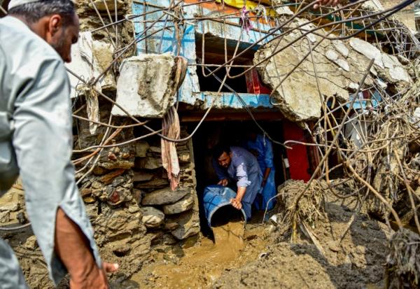 Un homme retire la boue de l'intérieur d'une maison suite aux crues subites dans la province montagneuse de Khyber Pakhtunkhwa au Pakistan le 16 août 2025
