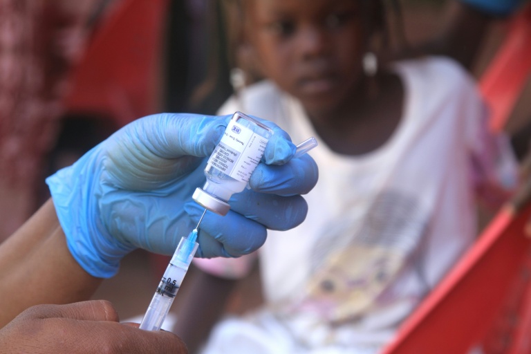 Un enfant soudanais observe la préparation d'un vaccin lors d'une campagne de vaccination contre la diphtérie dans un camp de déplacés dans la ville d'Al-Dabbah, dans le nord du Soudan, le 22 novembre 2025