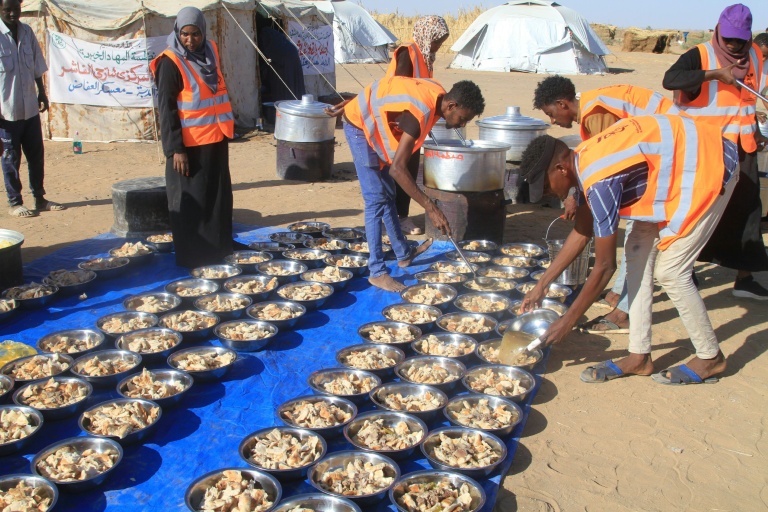 Des bénévoles préparent des repas gratuits pour ceux qui ont fui El-Fasher dans un camp de réfufiés à Al-Dabbah, au Soudan, le 20 novembre 2025