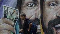 Un habitant passe devant une fresque murale liée aux taux de change à Caracas, au Venezuela, le 2 juin 2025