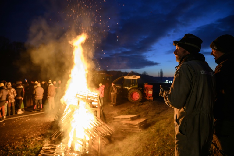 Des agriculteurs se réchauffent autour d'un feu, près de Léguevin (Haute-Garonne), le 7 janvier 2026 