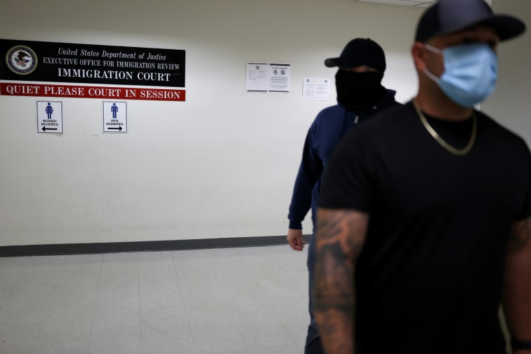 Des officiers en civil de la police fédérale de l'immigration (ICE) attendent dans un couloir d'un tribunal fédéral de l'immigration à New York le 6 juin 2025.