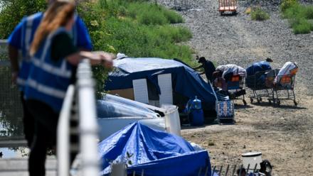 Des employés d'une association d'aide aux sans-abris veillent sur un campement de SDF, à Los Angeles, le 1er juin 2026