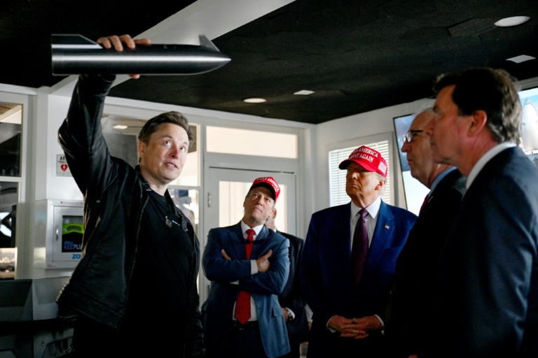 Elon Musk (g) et le président élu américain Donald Trump (3e g) dans une salle de contrôle avant le lancement d'un vol d'essai de la fusée Starship de SpaceX, le 19 novembre 2024 à Brownsville, au Texas