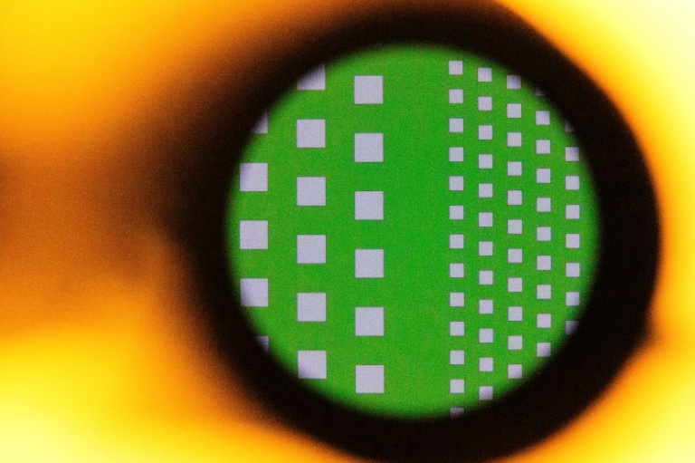 A silicon wafer seen magnified through the lens of a microscope