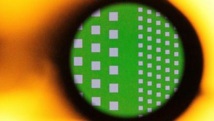 A silicon wafer seen magnified through the lens of a microscope