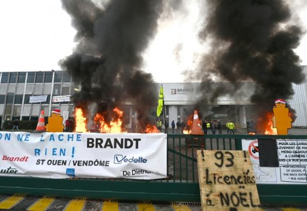 Des palettes brûlent devant l'usine Brandt où sont rassemblés des employés, le 11 décembre 2025 à Vendôme, dans le Loir-et-Cher