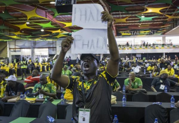 Lors d'une réunion du Congrès national africain (ANC) à Johannesburg, le 16 décembre 2022, un délégué brandit une pancarte où l'on peut lire "Phala Phala", en référence à un vol survenu dans la ferme du même nom appartenant au président sud-africain Cyril Ramaphosa