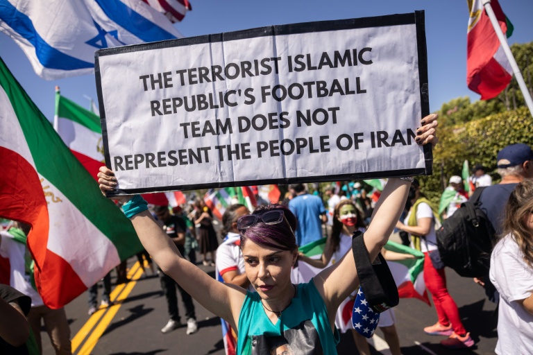 Une manifestante brandit une pancarte assurant que l'équipe de football d'Iran 
